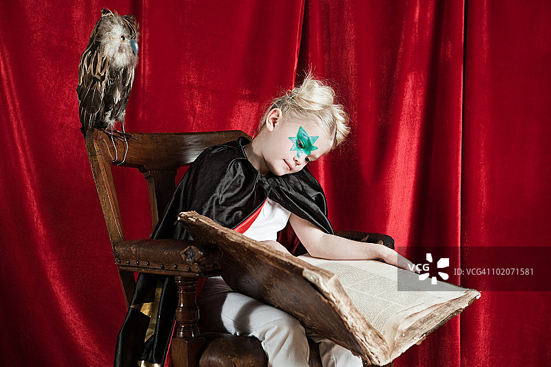 装扮成巫师的年轻女孩抱着魔法书睡着了图片素材