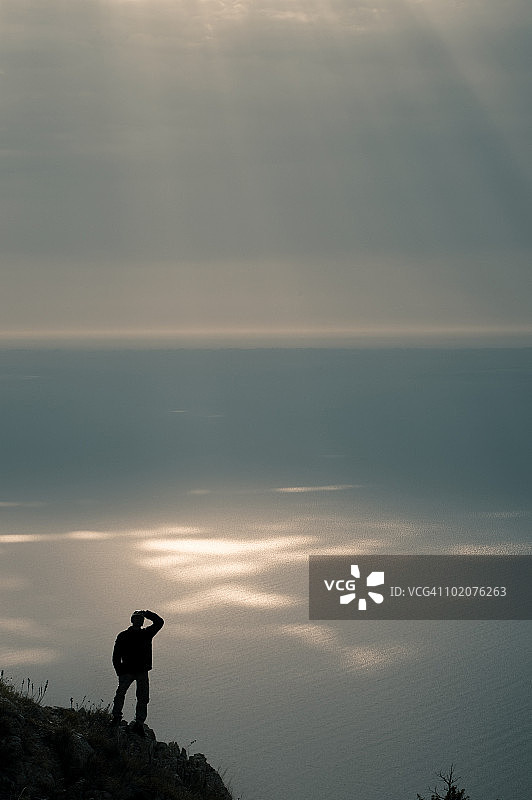 乌克兰克里米亚阿卢普卡：阿卢普卡墙，悬崖上俯瞰大海的人的轮廓图片素材