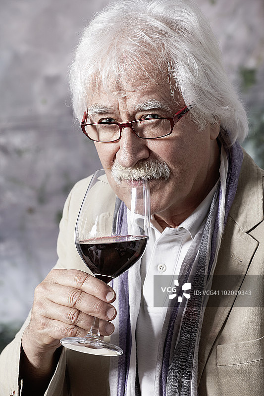 品尝葡萄酒的成熟男人肖像图片素材