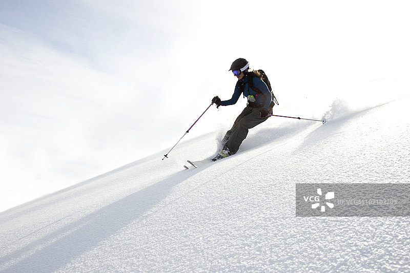 女子在刚下的雪地上滑雪图片素材