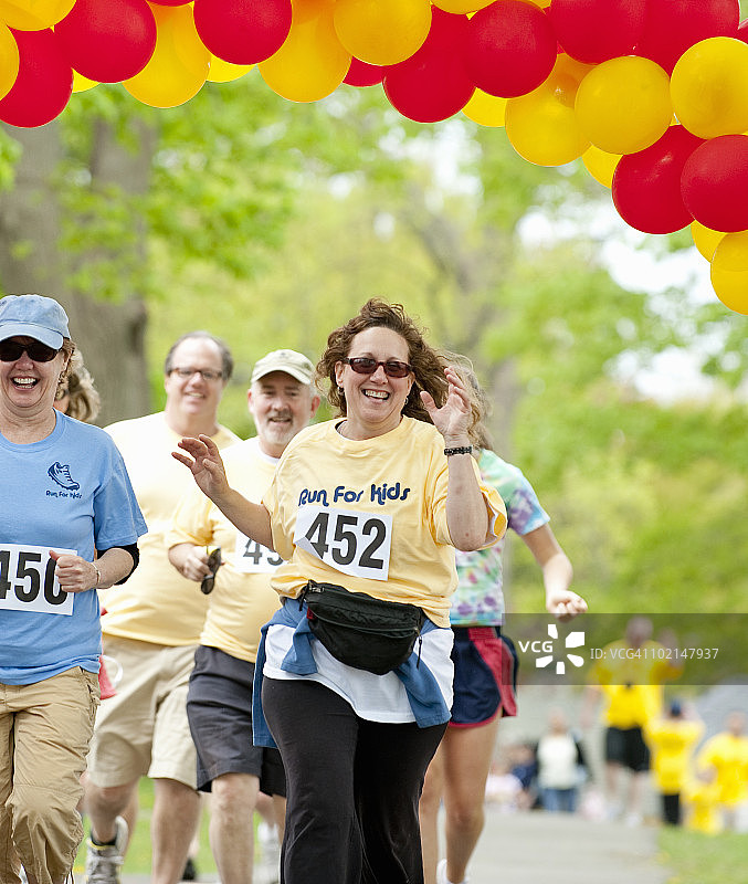 赛跑者在慈善比赛中冲过终点线图片素材