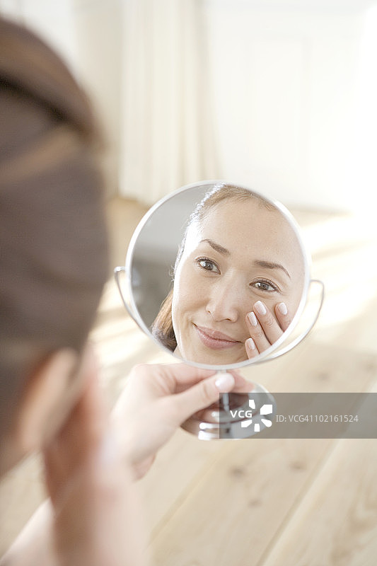 看着手持镜子的中年妇女图片素材
