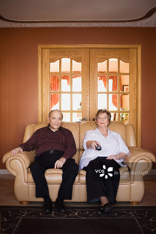 老年男人和女人坐在沙发上的肖像图片素材