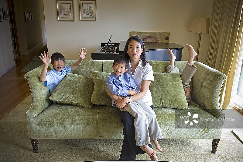 严肃的母亲和三个儿子在沙发上图片素材