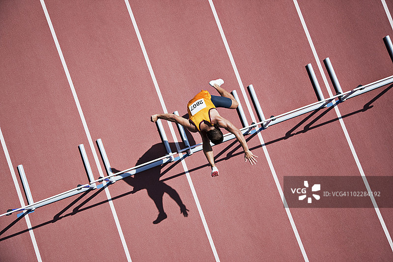 跑步者在赛道上跳跨栏图片素材