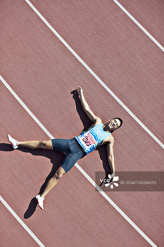 疲惫的跑步者躺在跑道上图片素材