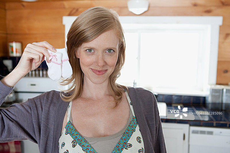 女人拿着婴儿袜图片素材