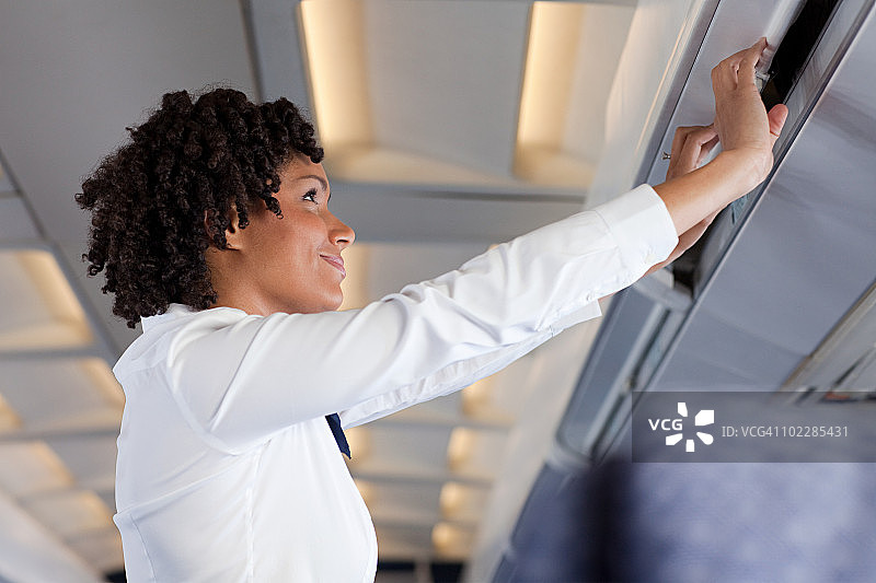 女乘务员关闭飞机储物柜图片素材