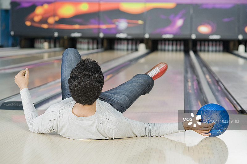 年轻人在保龄球馆摔倒图片素材