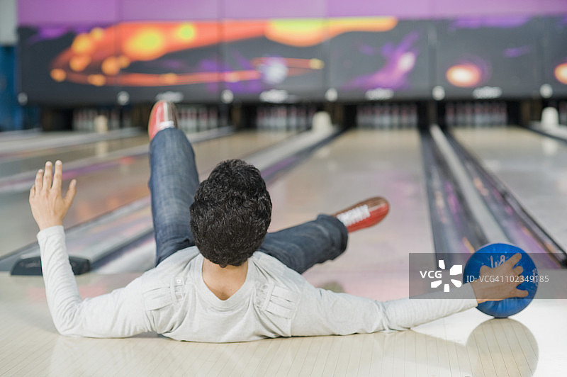 年轻人在保龄球馆摔倒图片素材
