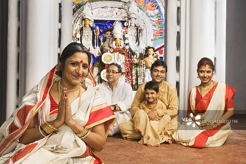 与家人在寺庙祈祷的女人图片素材