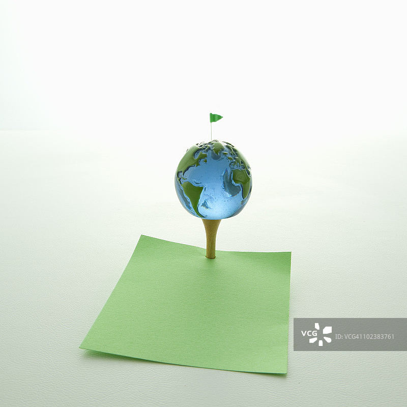高尔夫球座上的地球和绿色空白纸条图片素材