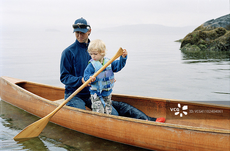 父亲教儿子如何划独木舟图片素材