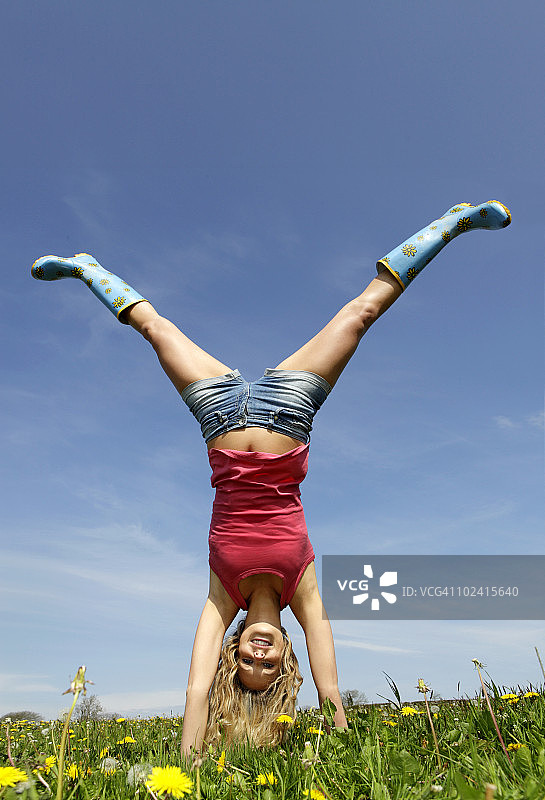 女人在田野里做倒立图片素材