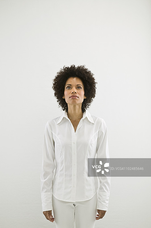 身穿白衣、在白色背景中向上看的女人图片素材
