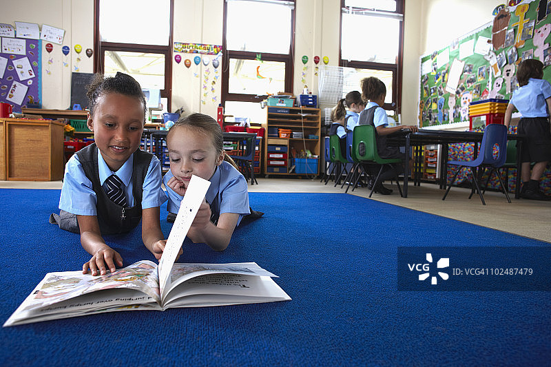 两名小学生一起阅读图片素材