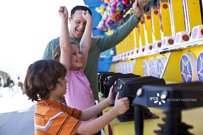一家人在游乐场玩射击游戏图片素材