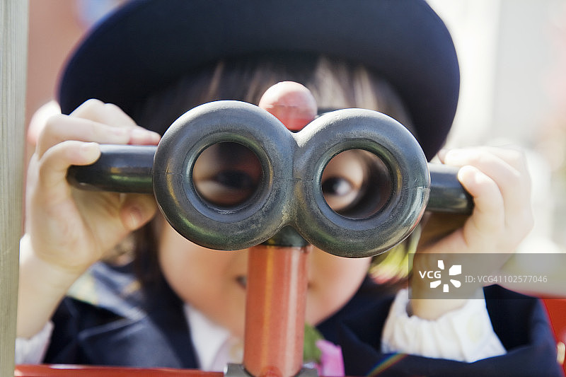 幼儿园里玩双筒望远镜的女孩图片素材