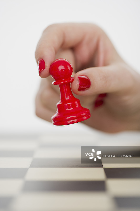 手持红色兵卒棋子图片素材
