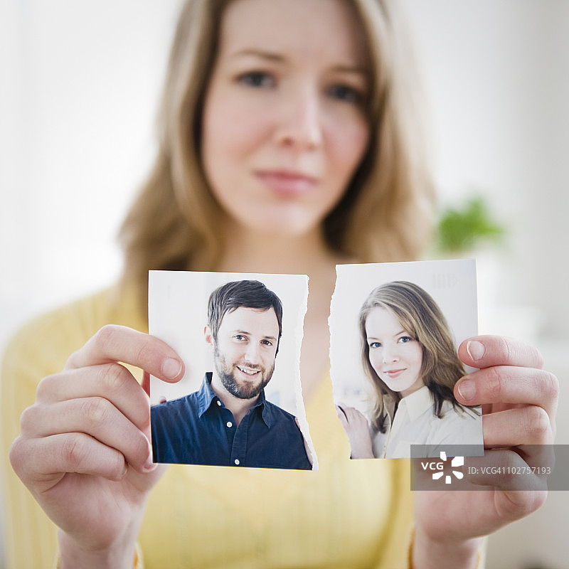 手持撕毁照片的女人图片素材