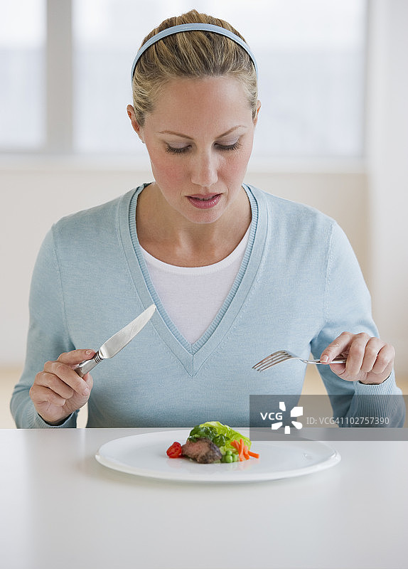 女人正在吃少量食物图片素材