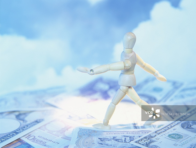 在纸币上行走的模特,背景是多云的天空图片素材