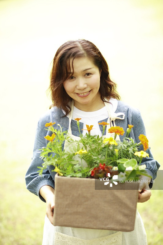 年长的女人在后院拿着鲜花图片素材