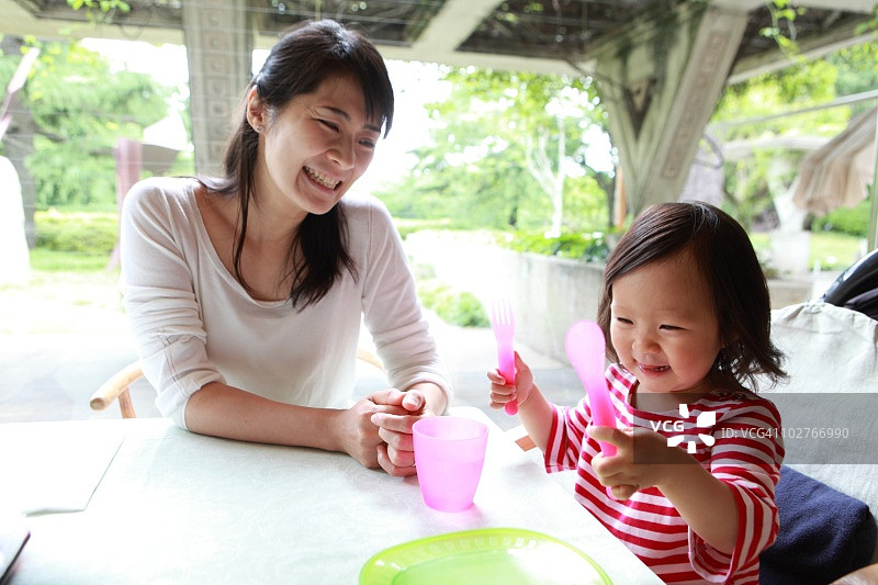 母女坐在桌旁等待食物图片素材