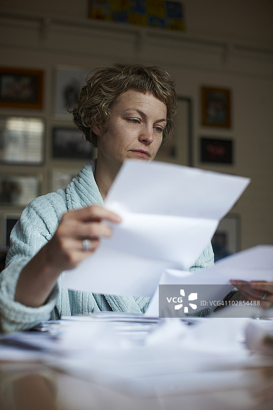 穿着睡袍的女人整理文件图片素材