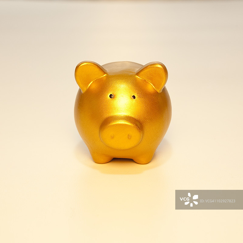白色背景上的金色小猪储蓄罐图片素材