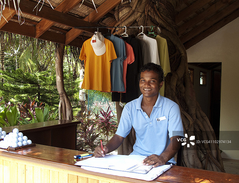 年轻马尔代夫员工在度假村高尔夫商店工作图片素材