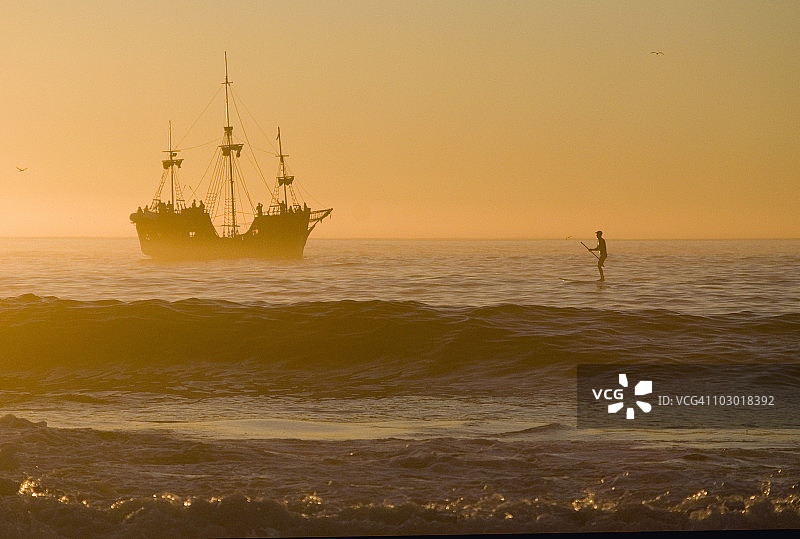 日落时分，克利夫顿海滩上的帆船和冲浪者，南非开普敦图片素材