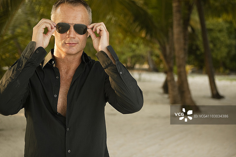 戴墨镜的中年男人在岛屿度假村图片素材