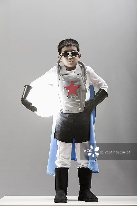 身穿超级英雄服装的韩国男孩手持发光球体图片素材