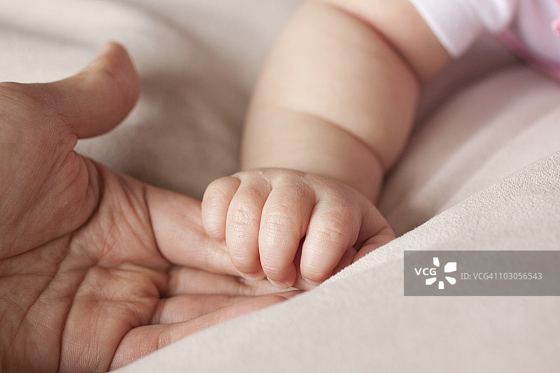 中国父亲握着婴儿的手图片素材