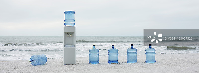 海滩上排列的饮水机和水桶图片素材