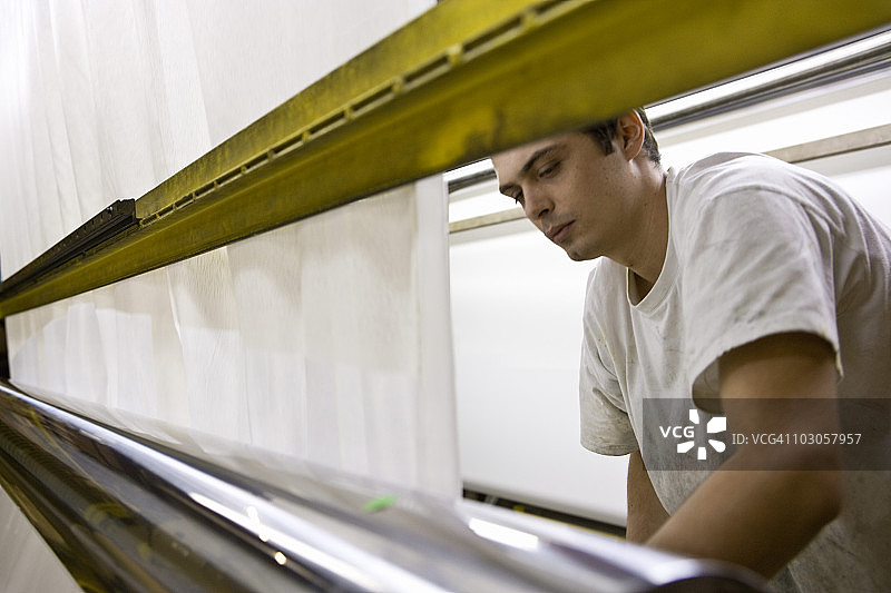 织物涂层工厂生产线上的机械师图片素材