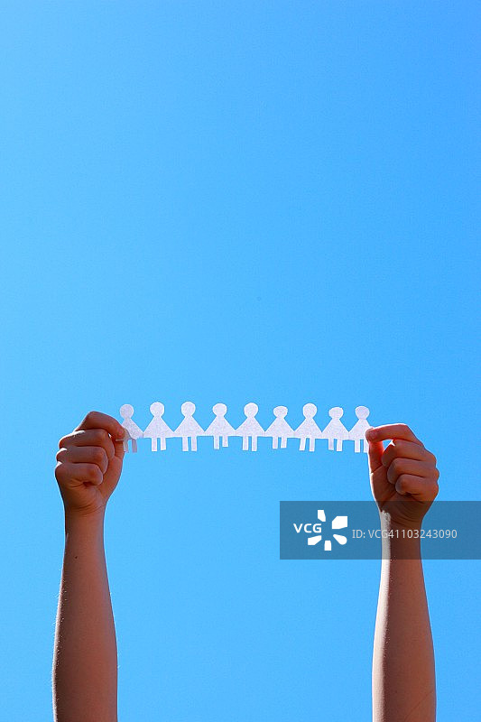 手持蓝色天空下的剪纸女孩图片素材