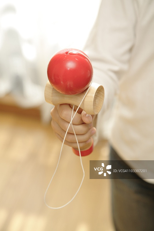 孩子拿着传统的剑玉玩具图片素材