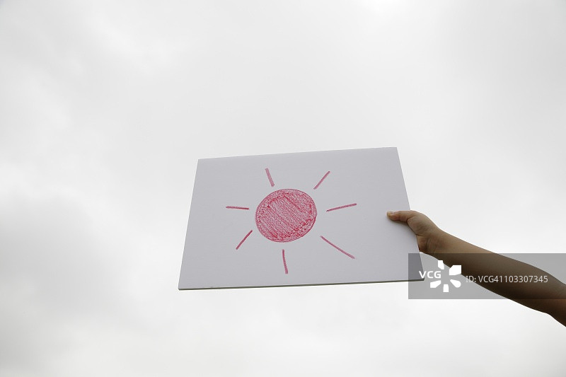 手持多云天空中的太阳照片图片素材