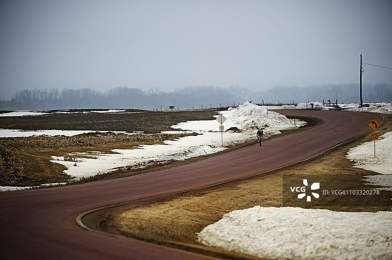 在寒冷多雾的冬日骑自行车的男人图片素材