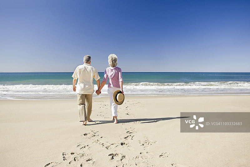 老年夫妇在海滩上手牵手图片素材