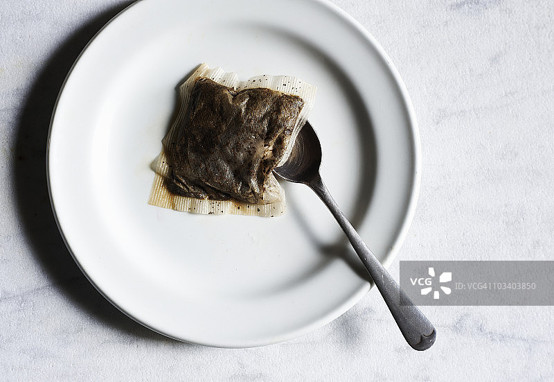 带勺子的盘子上的茶包图片素材