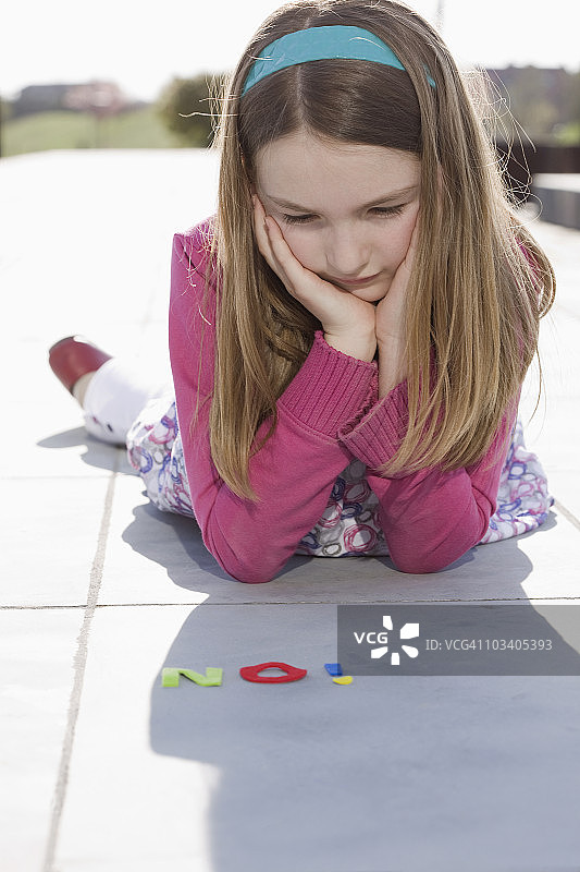 女孩看着用毛毡字母拼写的“NO”图片素材