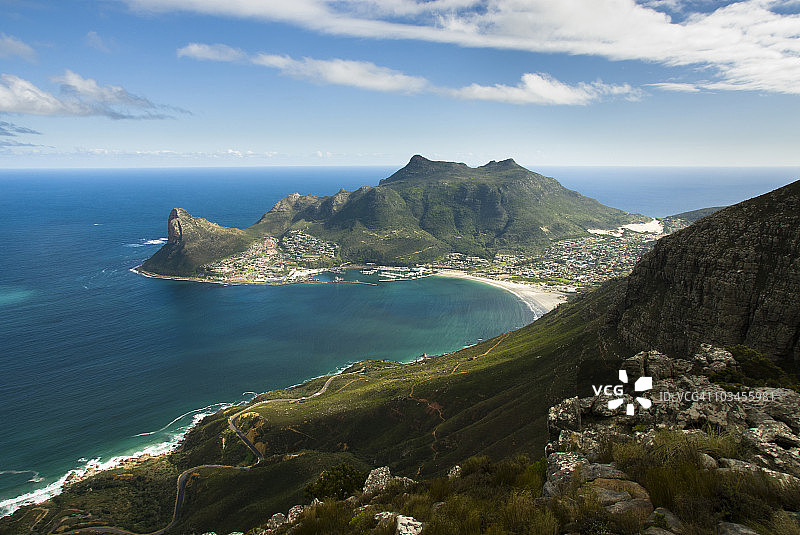 从山上俯瞰豪特湾港口和城镇，哨兵峰和卡邦克尔伯格峰，以及下方的沿海公路。豪特湾，开普半岛，西开普省，南非图片素材