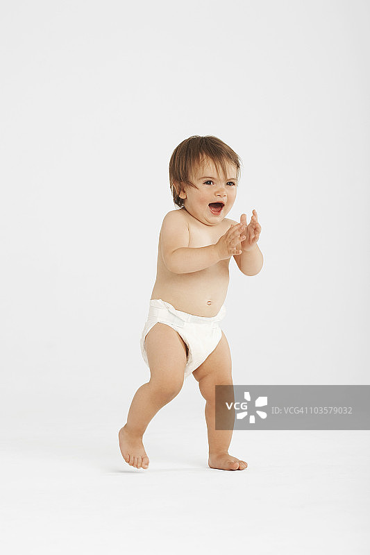 兴奋的幼儿在白色工作室迈出第一步图片素材