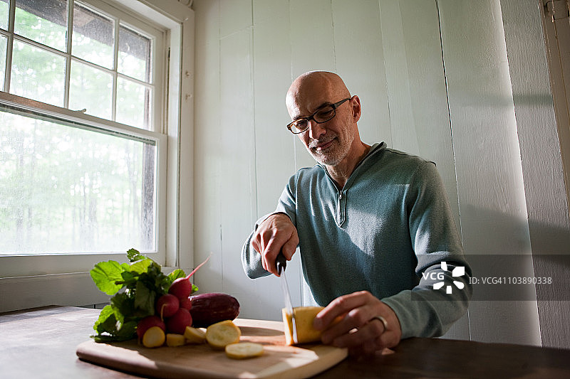 在室内准备食物的年长男人图片素材