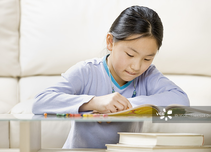 在涂色书上涂色的年轻女孩图片素材