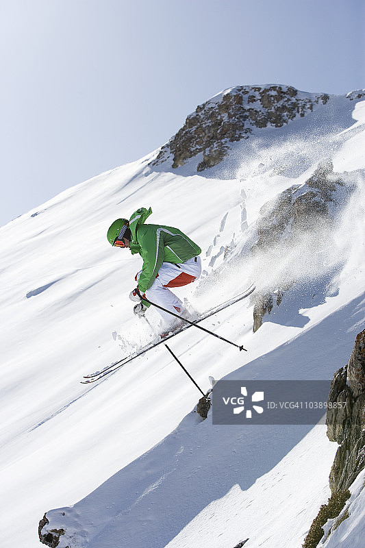 滑雪者从岩石上跳下图片素材