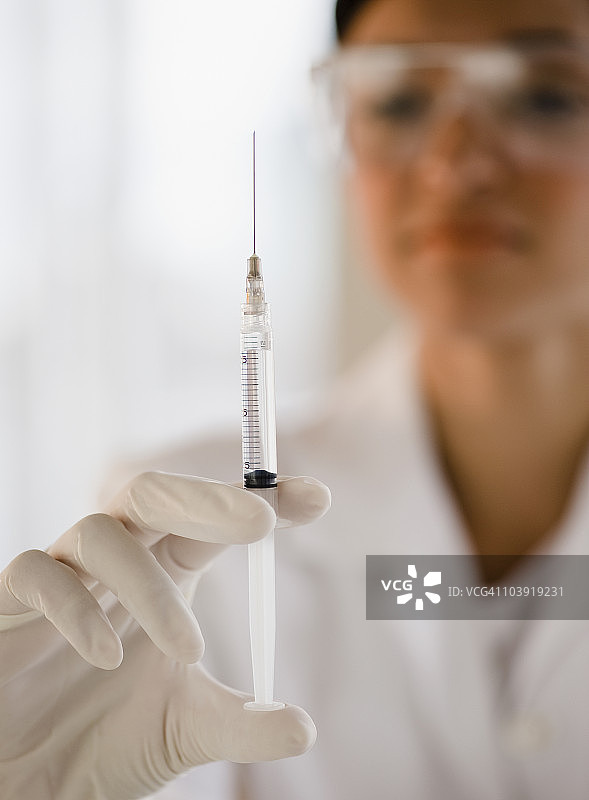 手持注射器的不同种族医生图片素材